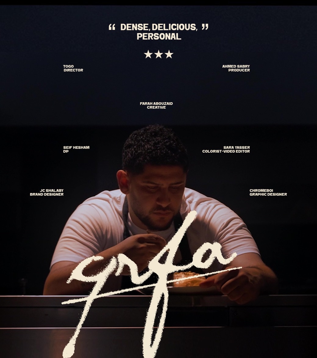 The QRFA one sheet: a baker leaning over a plate in near darkness, the brush-script qrfa wordmark large across the lower third, a three-star pull quote reading 'dense, delicious, personal' at the top, and the crew billed in small pairs scattered left and right of the figure.